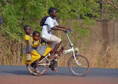Two girls in Ghana get a ride to school. A cycle is a way of speeding up long walks. Photograph: Remo Kurka/Alamy